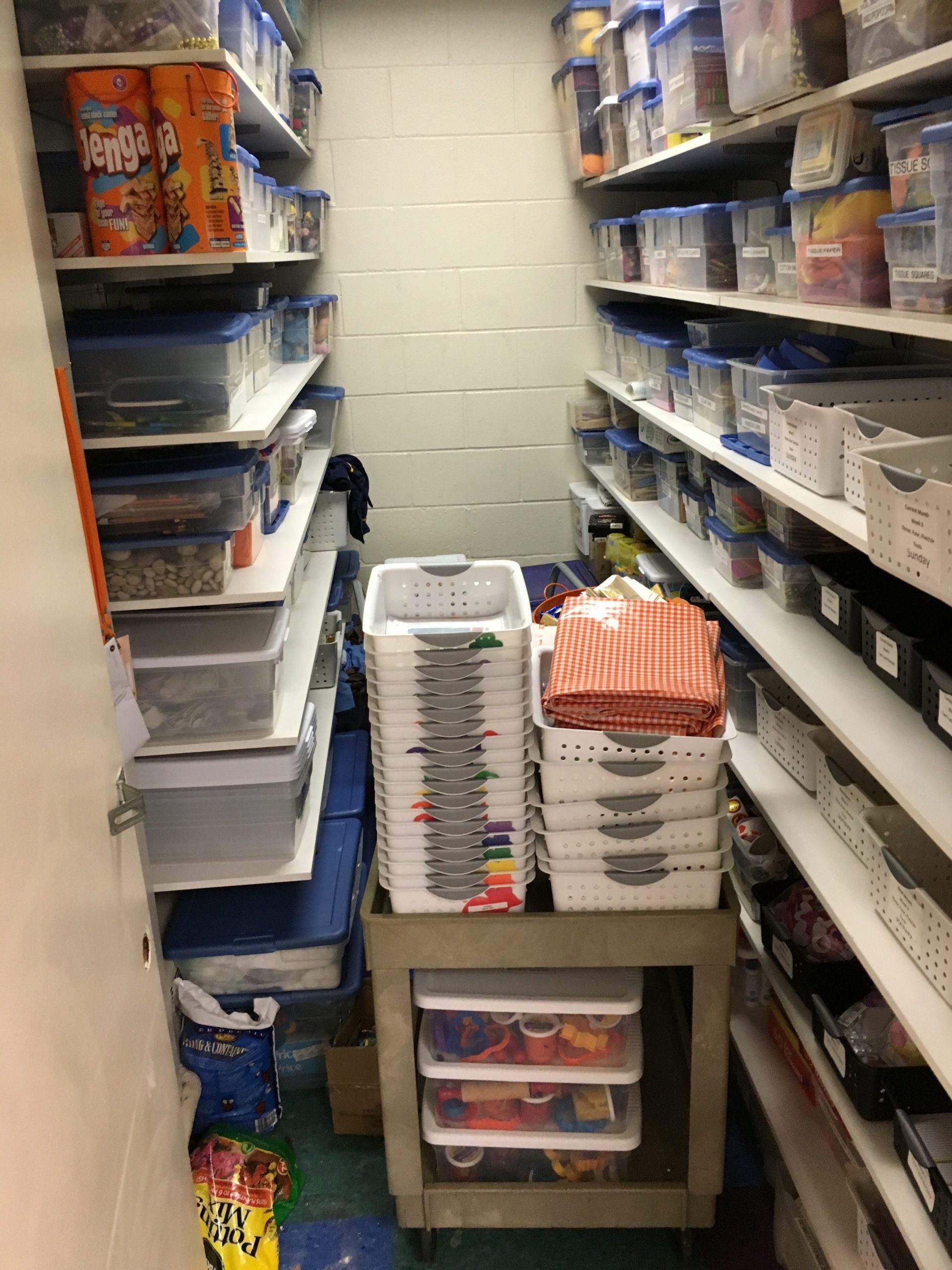 Rolling storage cart that can be moved out of the way. Small bins can be used for each small group.